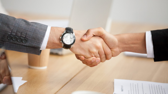 Close up view of handshake, two businessmen in suits shaking hands as concept of trust, good partnership deal, signing contract agreement at meeting, gratitude for help support in business