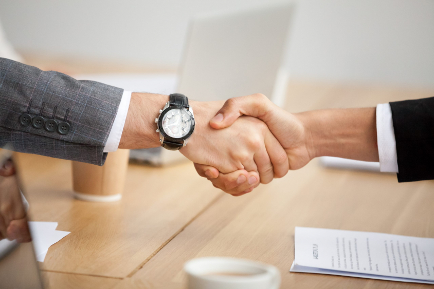 Close up view of handshake, two businessmen in suits shaking hands as concept of trust, good partnership deal, signing contract agreement at meeting, gratitude for help support in business