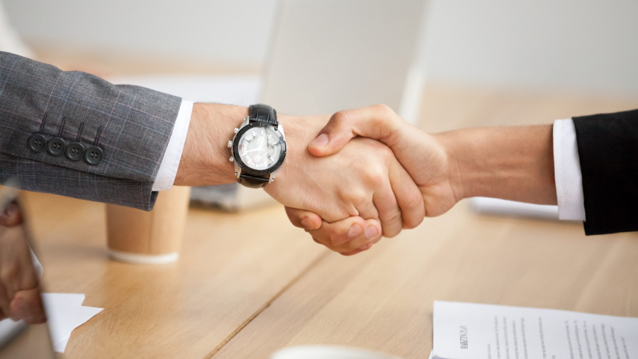 Close up view of handshake, two businessmen in suits shaking hands as concept of trust, good partnership deal, signing contract agreement at meeting, gratitude for help support in business
